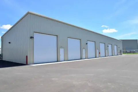 Steel storage building at SYT Storage with white 14-foot overhead doors and a man door beside each unit